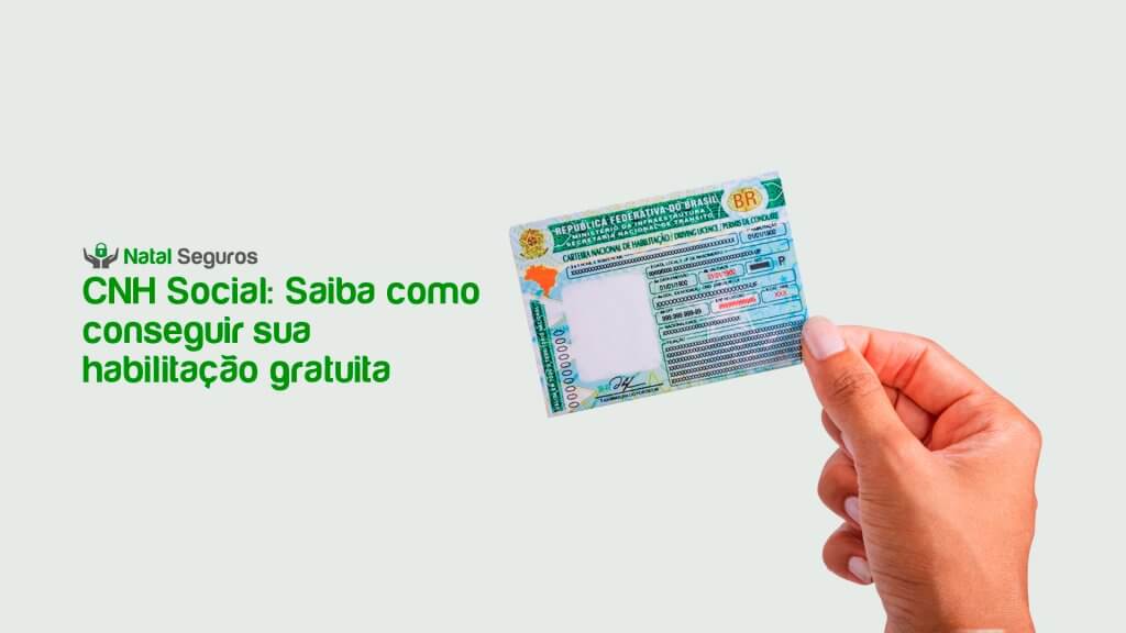 A imagem apresenta um fundo branco com um leve tom verde. No canto superior esquerdo, há o logo da Natal Seguros, que consiste em um cadeado estilizado entre um par de mão. Abaixo do logo, em destaque, está o texto "CNH Social: Saiba como conseguir sua habilitação gratuita". A maior parte da imagem é ocupada por uma foto de uma mão segurando uma Carteira Nacional de Habilitação (CNH) brasileira. A CNH está posicionada de forma que seja possível visualizar a parte frontal com a inscrição "REPÚBLICA FEDERATIVA DO BRASIL" e o brasão nacional.
