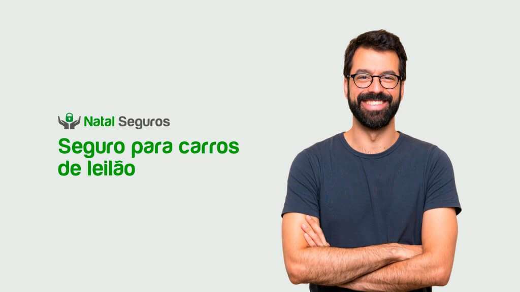 Esta imagem mostra um homem sorrindo e com os braços cruzados, posicionado à direita da imagem. À esquerda da imagem, há um texto em português que diz: Seguro para carros de leilão.