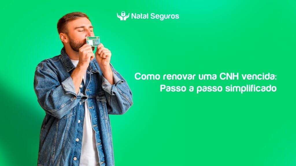 A imagem mostra uma pessoa segurando uma carteira de motorista (CNH) em frente ao rosto. A pessoa está vestindo uma jaqueta jeans e uma camiseta branca. O fundo da imagem é verde, e há um texto em branco no lado direito que diz: "Como renovar uma CNH vencida: Passo a passo simplificado". No canto superior direito, há um logotipo e o texto "Natal Seguros".