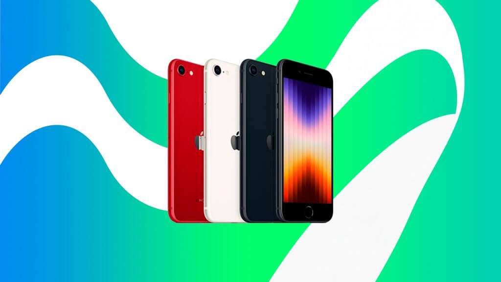 A imagem mostra quatro modelos do iPhone SE em diferentes cores: vermelho, branco, preto e um com a tela ligada exibindo um padrão de cores vibrantes. Os iPhones estão dispostos em uma linha diagonal, com o modelo vermelho à esquerda e o modelo com a tela ligada à direita. O fundo da imagem é composto por um padrão ondulado em tons de azul, verde e branco, criando um contraste visual interessante com os dispositivos. Esta imagem é relevante porque destaca as opções de cores disponíveis para o iPhone SE, além de mostrar o design e a tela do dispositivo.